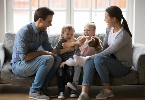 A family sitting on a couch with a dog - a heartwarming scene of togetherness and companionship.